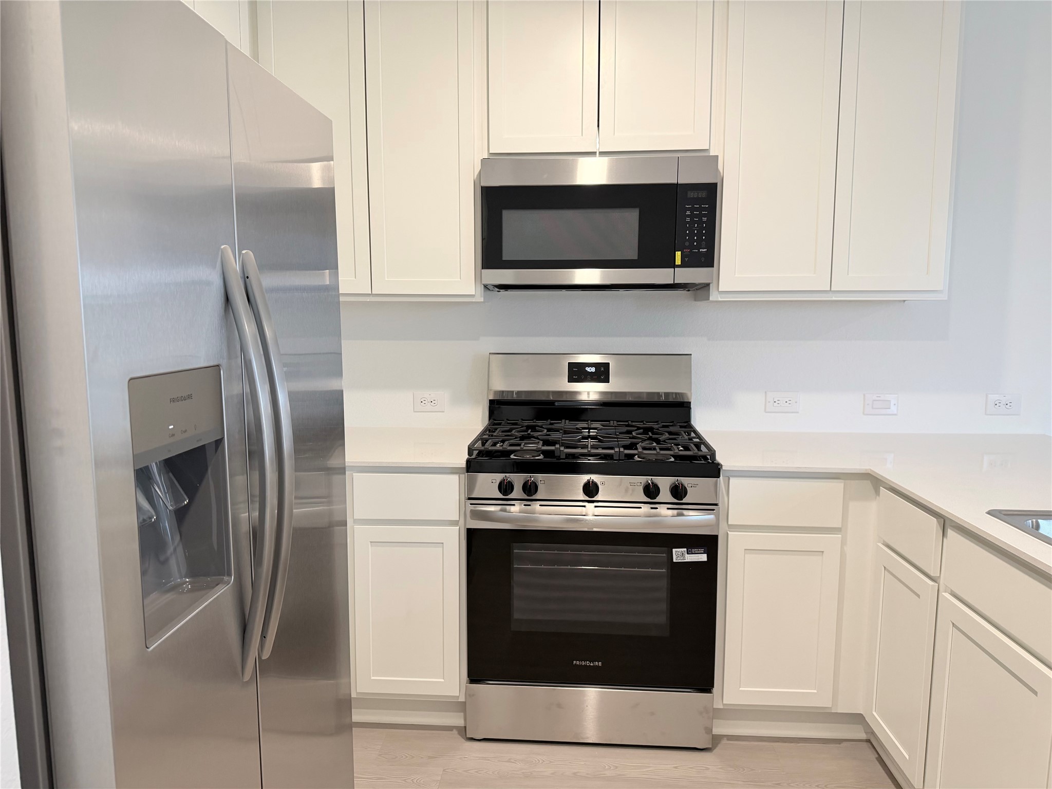 447 Southern Magnolia Way Magnolia, TX 77354 - Photo 10 of 21 a kitchen with stainless steel appliances granite countertop a stove a microwave and a refrigerator