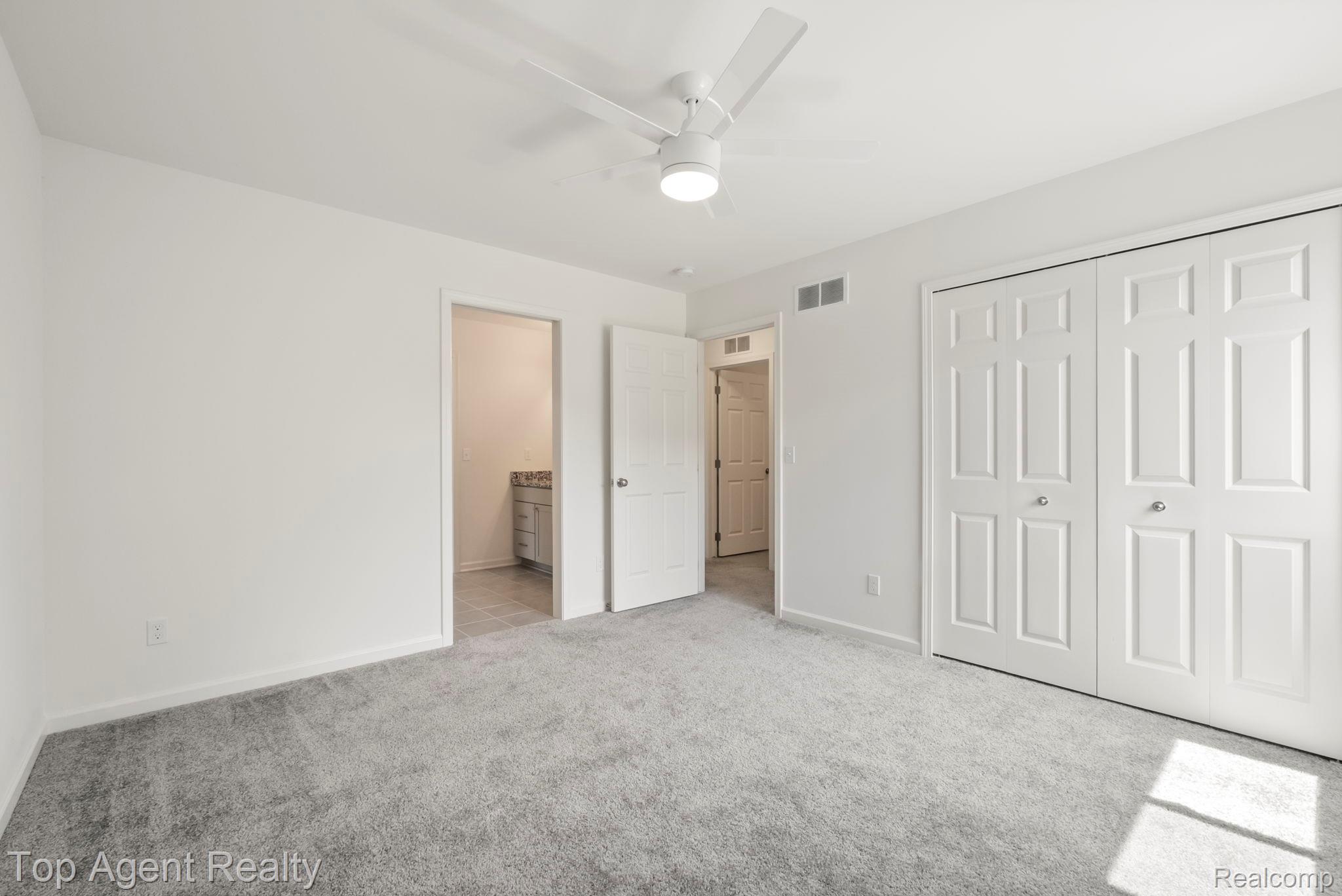 63770 Dequindre Road Washington, MI 48095 - Photo 39 of 61 Neutral-toned bedroom featuring plush gray carpeting, a contemporary ceiling fan with integrated lighting, and white bi-fold closet doors