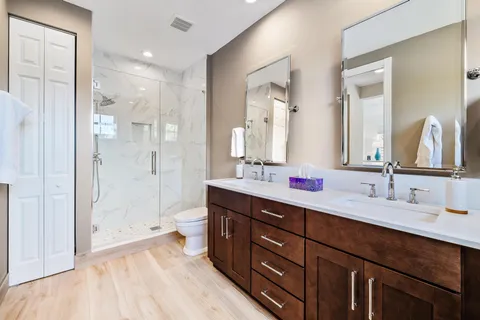 a spacious bathroom with a double vanity sink mirror double and shower