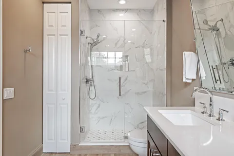 a bathroom with a sink a toilet and shower