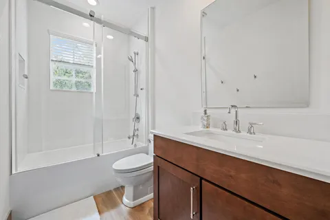a bathroom with a sink a toilet and shower