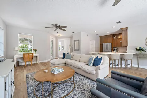 a living room with furniture a dining table and a chandelier