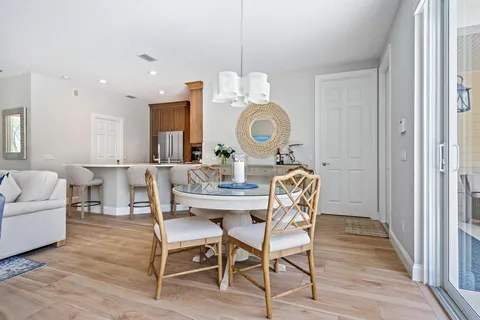 a dining room with wooden floor a glass table and chairs
