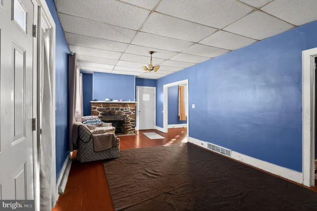 a living room with furniture a fireplace and gym equipment