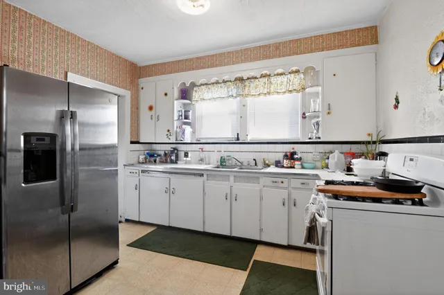 a kitchen with stainless steel appliances granite countertop a sink and a refrigerator