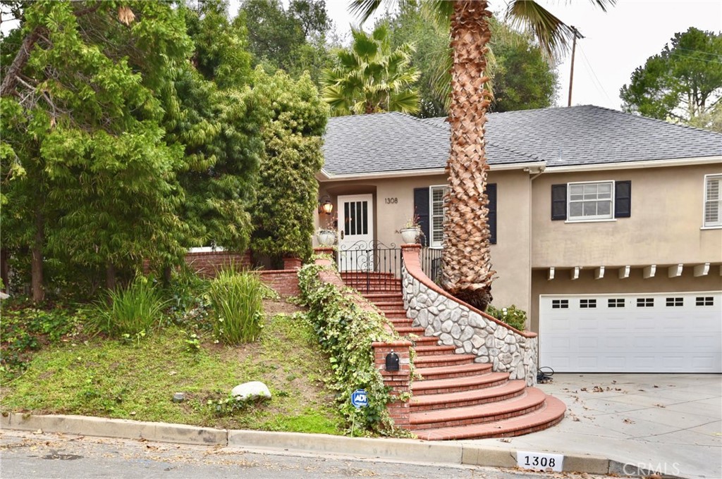 a front view of house with yard and trees around