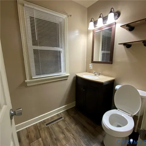 a bathroom with a toilet sink vanity and mirror