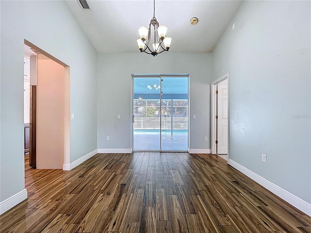 18812 Bascomb Lane Hudson, FL 34667 - Photo 20 of 57 a view of a room with wooden floor chandelier and windows