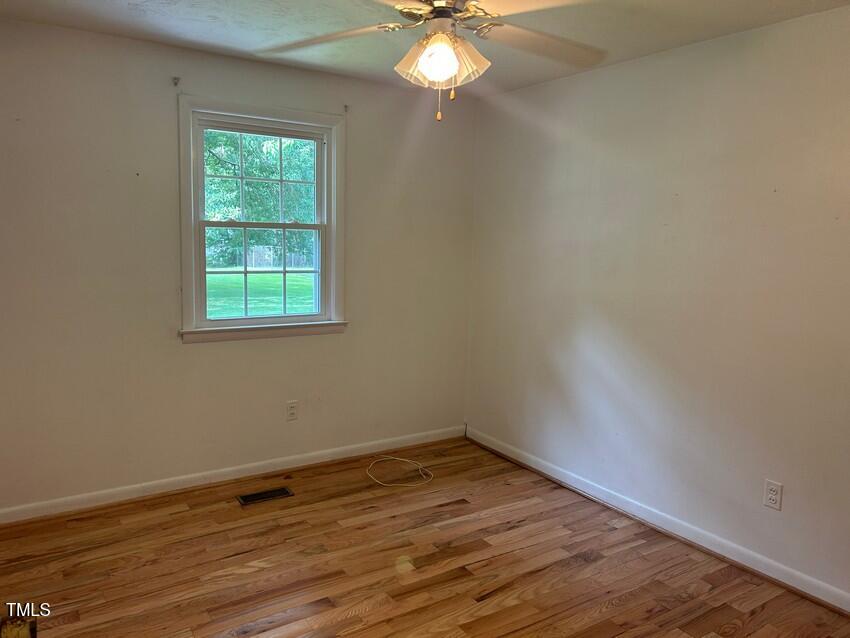 111 Colonial Drive Clinton, NC 28328 - Photo 13 of 21 an empty room with wooden floor and windows