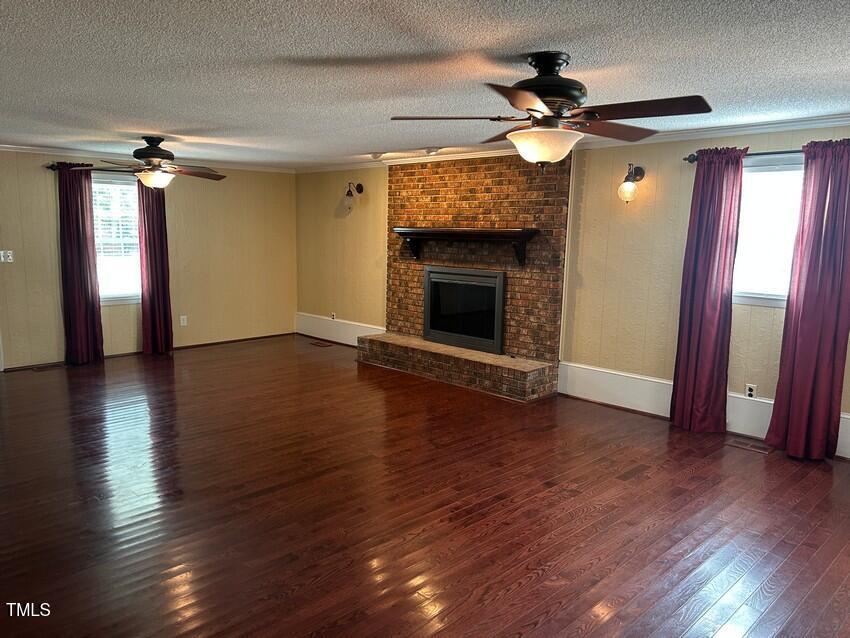 111 Colonial Drive Clinton, NC 28328 - Photo 7 of 21 a view of an empty room with wooden floor and a fireplace