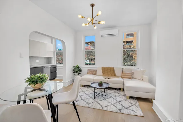 a living room with furniture a chandelier and a window