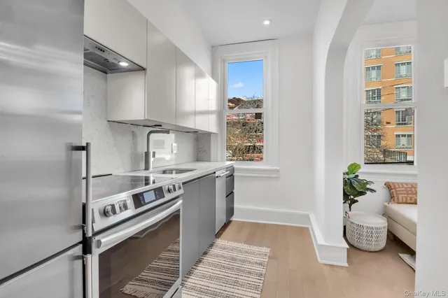 a kitchen with stainless steel appliances granite countertop a sink a stove and a refrigerator