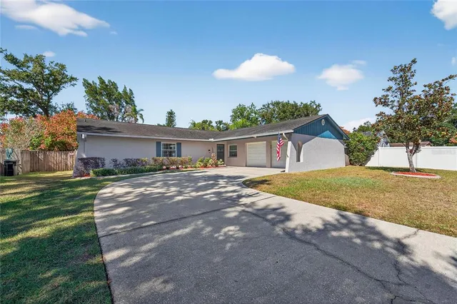 a front view of a house with a yard and potted plants
