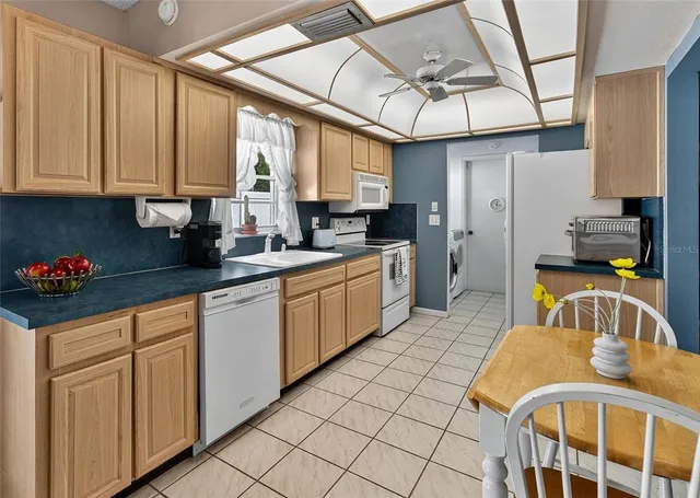 a kitchen with stainless steel appliances granite countertop a sink a stove cabinets counter space and a window