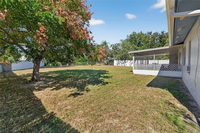 an aerial view of a house with swimming pool and outdoor seating