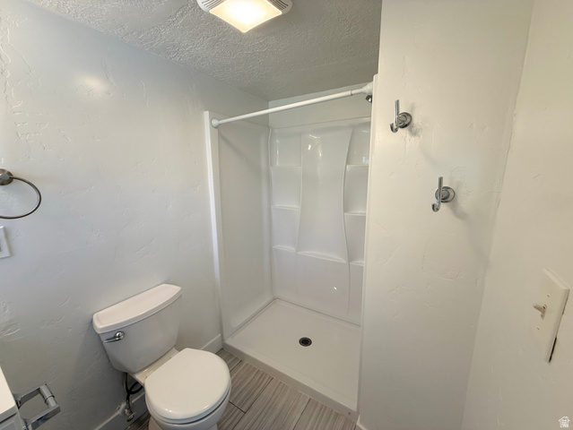 548 27th Street Ogden, UT 84403 - Photo 8 of 13 Bathroom featuring a stall shower, a textured ceiling, and a textured wall