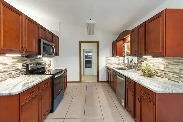 a large kitchen with stainless steel appliances granite countertop a stove sink and cabinets