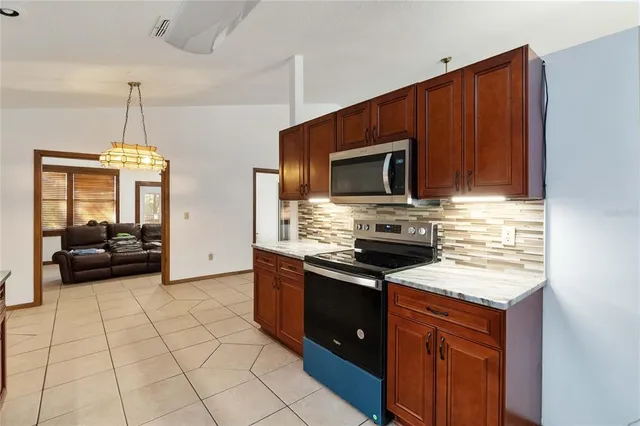 a kitchen with stainless steel appliances granite countertop a stove a sink and a microwave