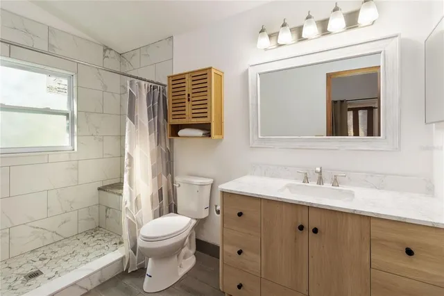 a bathroom with a sink a toilet and shower