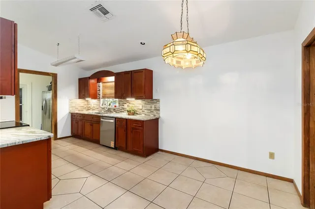 a kitchen with stainless steel appliances granite countertop a sink a stove top oven a counter space and cabinets