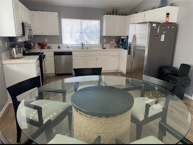 a kitchen with a table chairs refrigerator and microwave