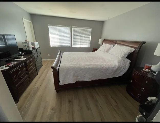 a bedroom with a bed and wooden floor