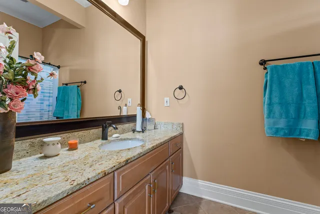 a bathroom with a granite countertop sink and a mirror
