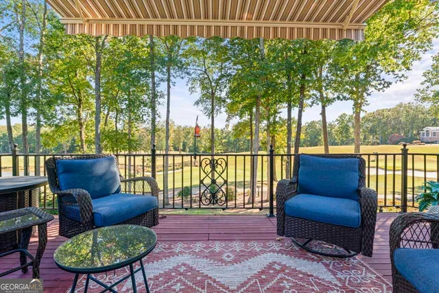 a balcony with wooden floor table and chairs