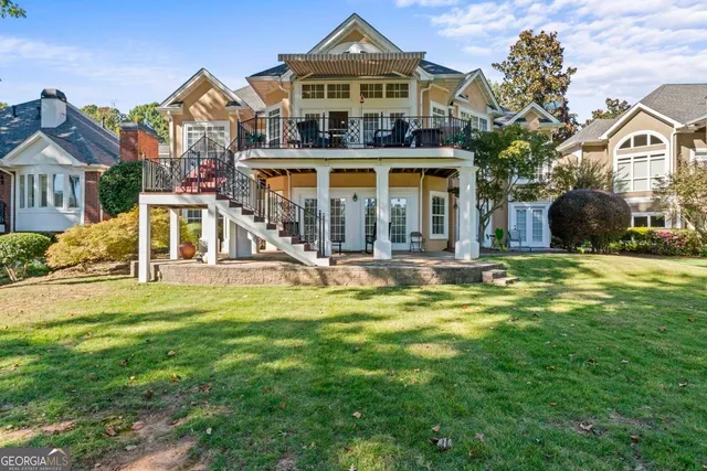 a view of a big house with a big yard and large trees
