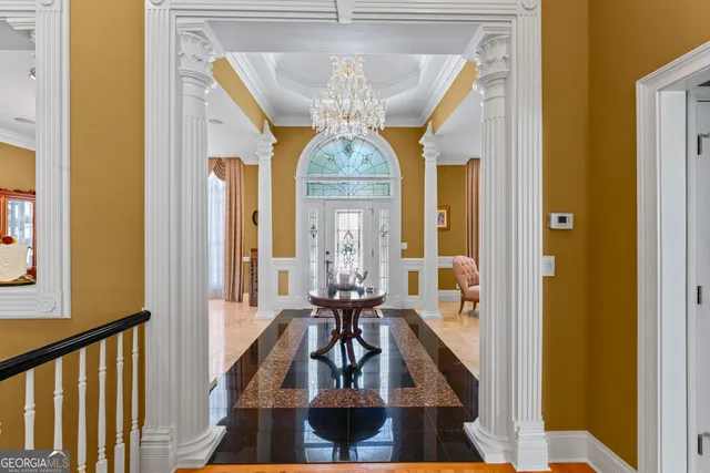 a view of a hallway with wooden floor and chandelier