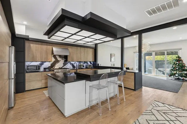 a kitchen with stainless steel appliances kitchen island granite countertop a stove and a refrigerator