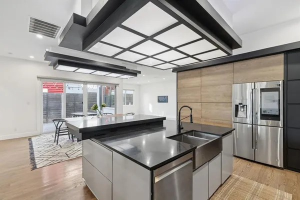 a kitchen with granite countertop a sink cabinets and stainless steel appliances