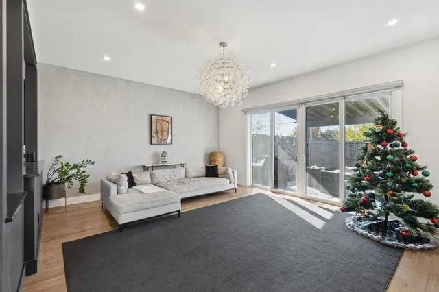 a living room with couch flowers and a chandelier