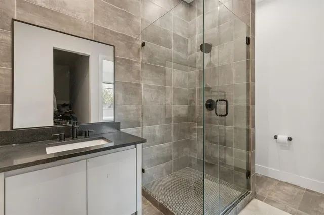 a bathroom with a shower sink and mirror