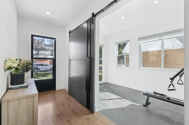 a view of a hallway with wooden floor and a living room