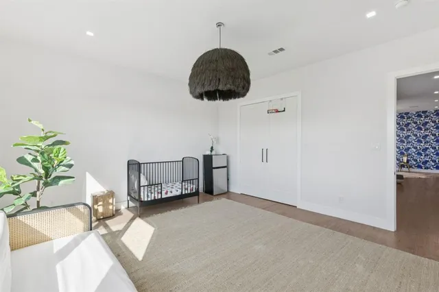a bedroom with a bed a rug and a potted plant