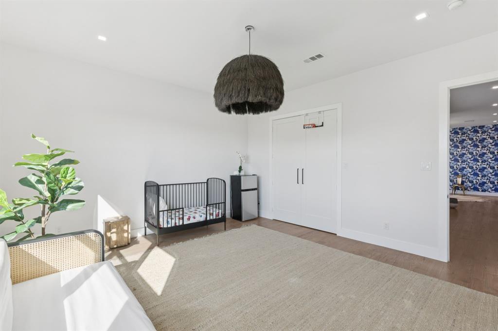 2231 Madera Street Dallas, TX 75206 - Photo 23 of 37 a bedroom with a bed a rug and a potted plant