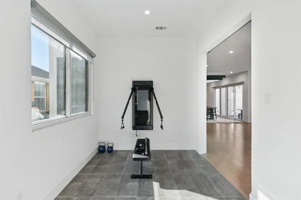 a picture of empty room with wooden floor and windows