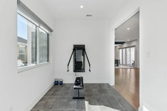 a picture of empty room with wooden floor and windows