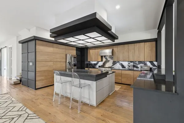 a living room with stainless steel appliances kitchen island granite countertop a table and chairs in it