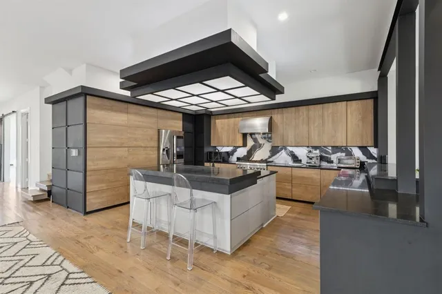 a living room with stainless steel appliances kitchen island granite countertop a table and chairs in it
