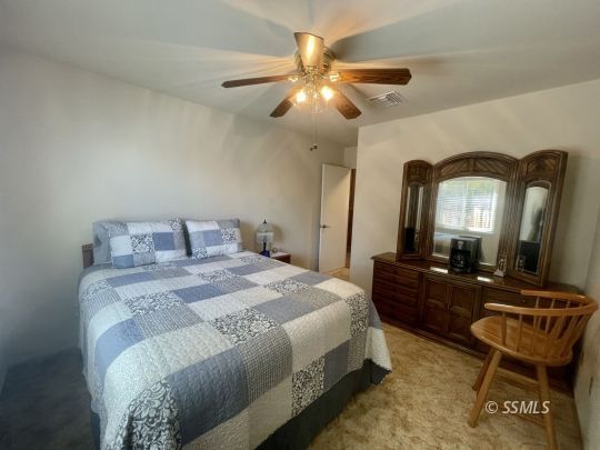 205 Chambers Street Ridgecrest, CA 93555 - Photo 15 of 32 a bedroom with a bed a mirror and furniture
