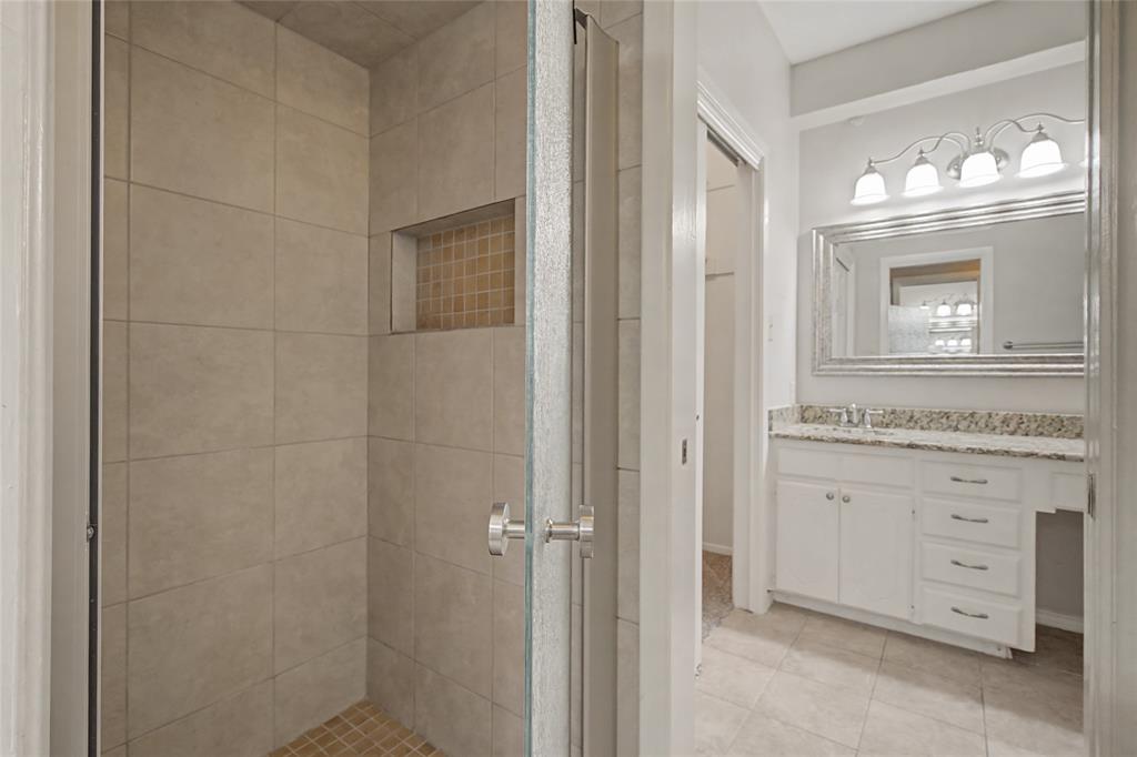 3200 Hickory Court Bedford, TX 76021 - Photo 18 of 30 Bathroom featuring a shower stall, vanity, and light tile patterned floors