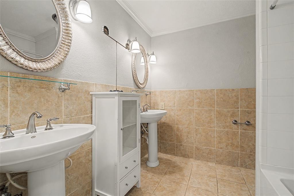 3200 Hickory Court Bedford, TX 76021 - Photo 21 of 30 Full bath with ornamental molding, two sinks, a textured wall, tile walls, and a bathtub