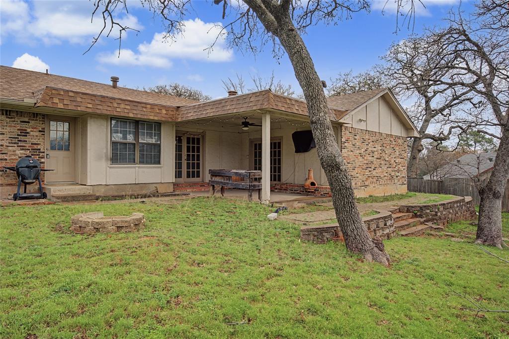 3200 Hickory Court Bedford, TX 76021 - Photo 27 of 30 Back of property with roof with shingles, a ceiling fan, a patio area, an outdoor fire pit, and brick siding