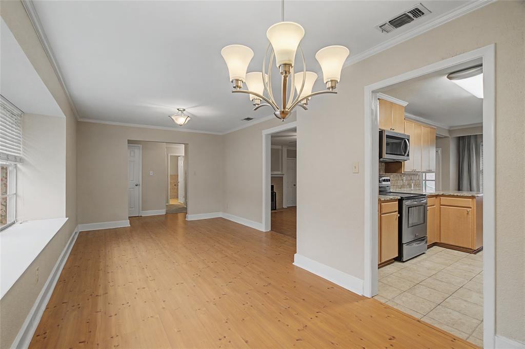 3200 Hickory Court Bedford, TX 76021 - Photo 6 of 30 Unfurnished dining area featuring a chandelier, crown molding, light wood finished floors, and plenty of natural light