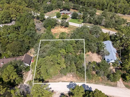 an aerial view of residential house with outdoor space and trees all around