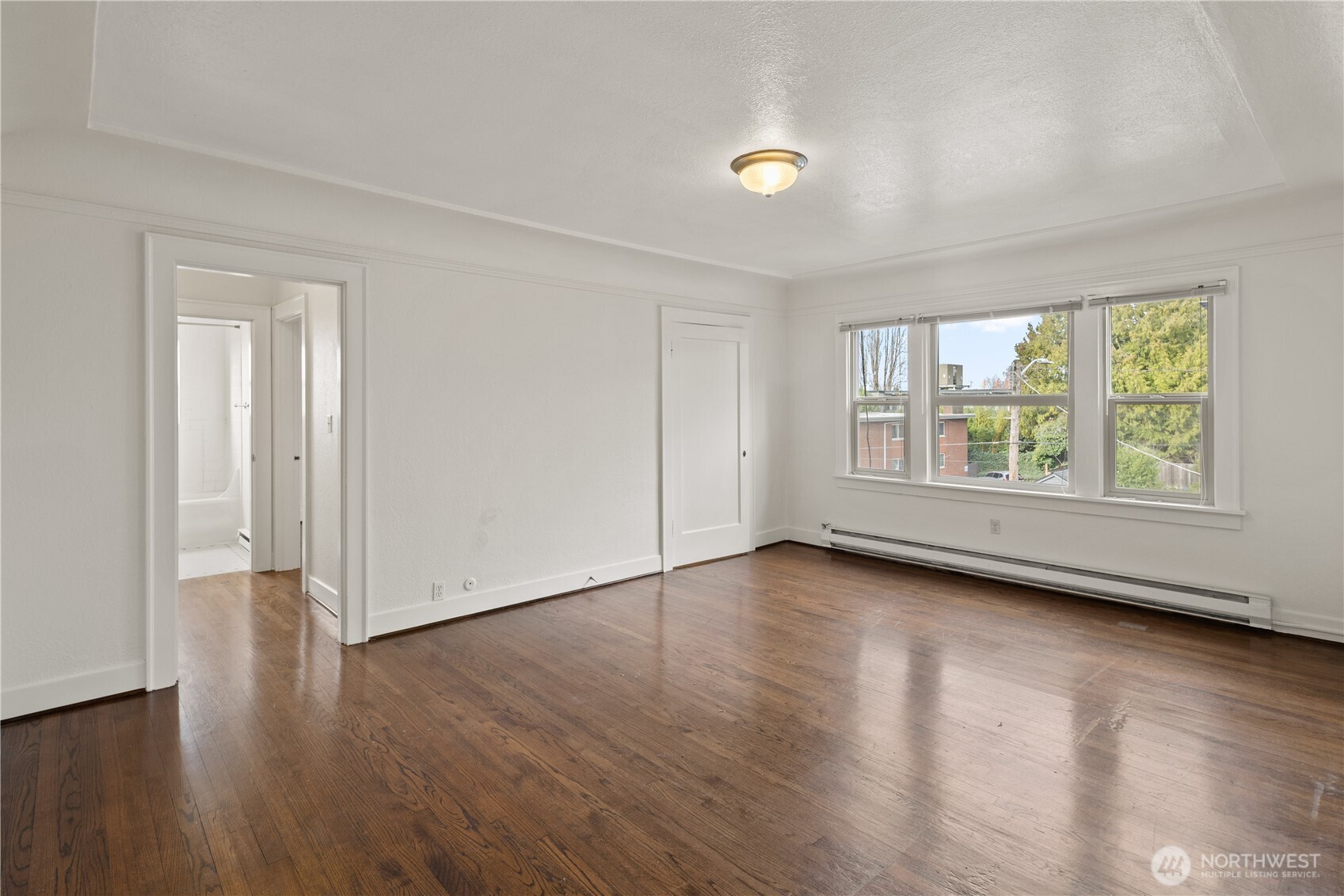 741 Federal Avenue East Seattle, WA 98102 - Photo 4 of 21 an empty room with wooden floor and windows