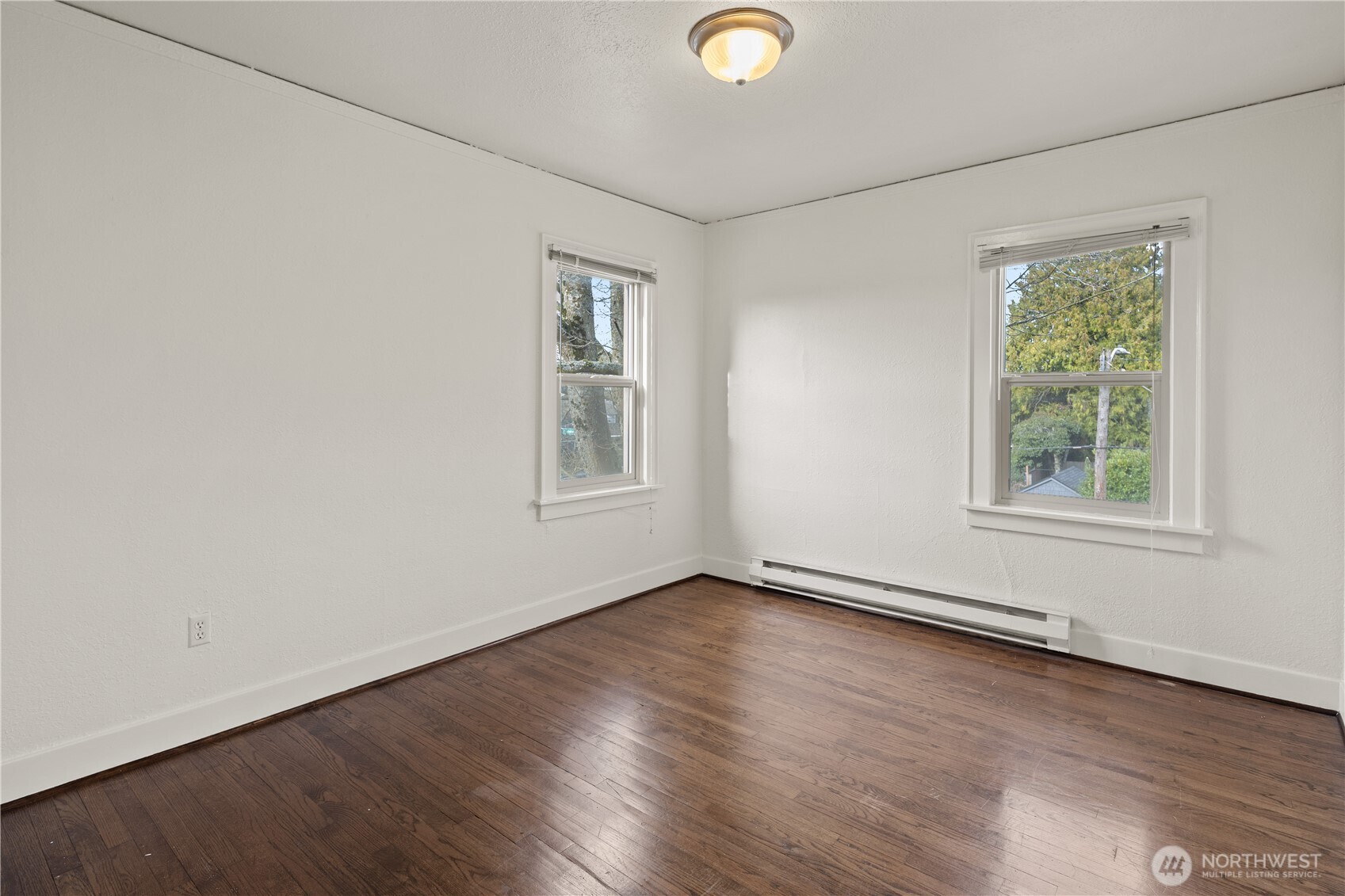 741 Federal Avenue East Seattle, WA 98102 - Photo 9 of 21 an empty room with wooden floor and windows