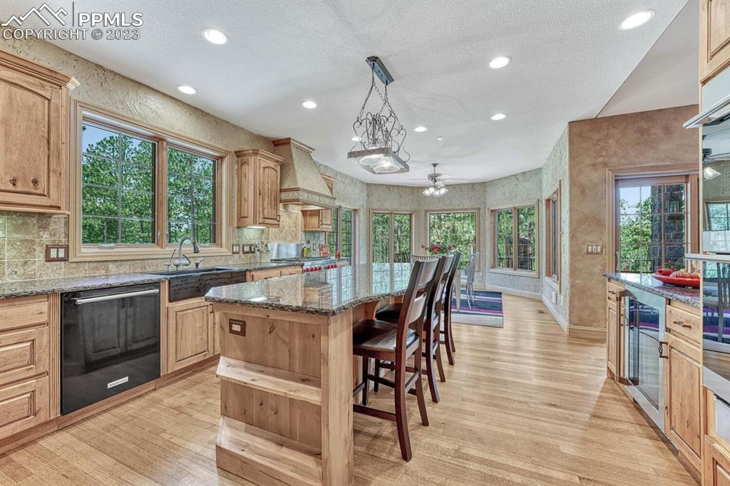 17890 Queensmere Drive Monument, CO 80132 - Photo 11 of 50 a kitchen with stainless steel appliances granite countertop dining table chairs and wooden cabinets